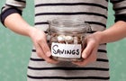 10 year old holding savings in jar 