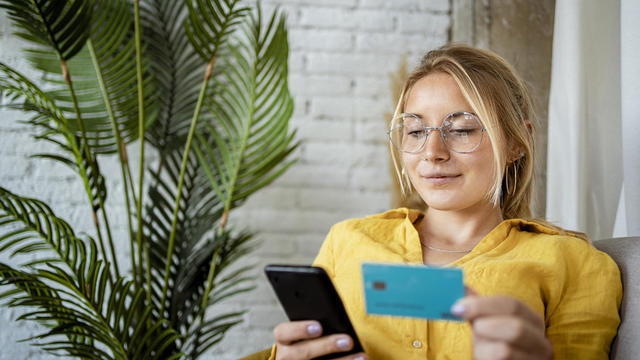 Female entrepreneur making online payment through credit card at home 