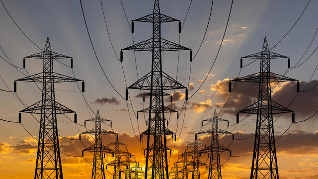 High voltage towers at sunset background. Power lines against the sky 