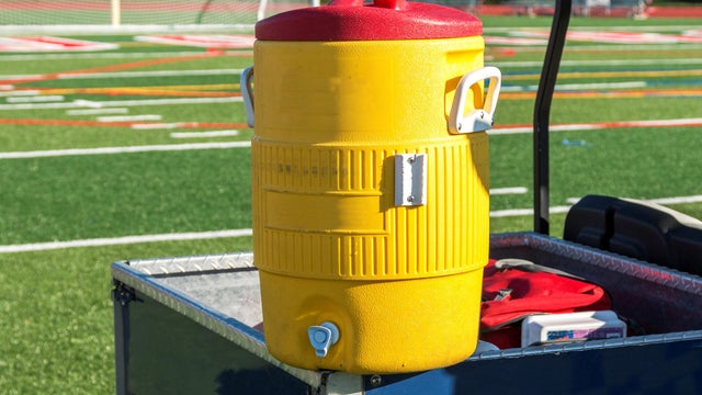 Yellow water cooler on a cart for the athletes 
