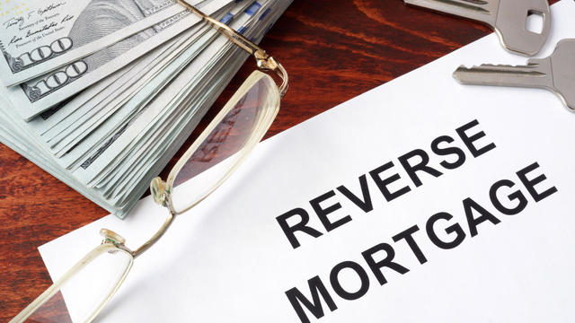 Reverse mortgage form on a table and money. 