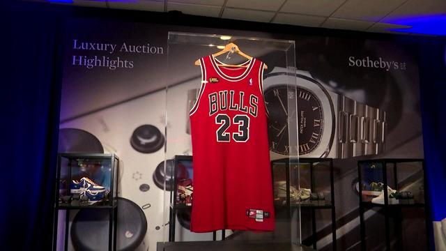A Michael Jordan Bulls jersey hangs in a glass case at Sotheby's. 