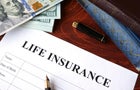 Life insurance policy and currency on a table. 