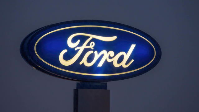 A view of an illuminated signboard with the Ford logo 