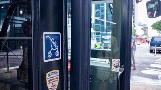 A sticker decal of an open stroller outside an MTA bus. 