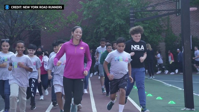 Olympian and marathon record-holder Beverly Ramos runs around a track with a group of schoolchildren. 