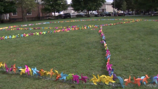 A giant peace sign made out of pinwheels planted in the grass in Harrison, New Jersey. 
