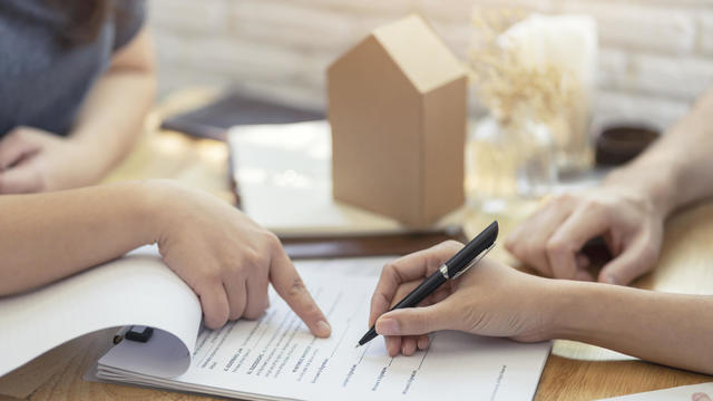 woman putting signature on document contract, real estate purchase, success business contract deals with sale represent. 