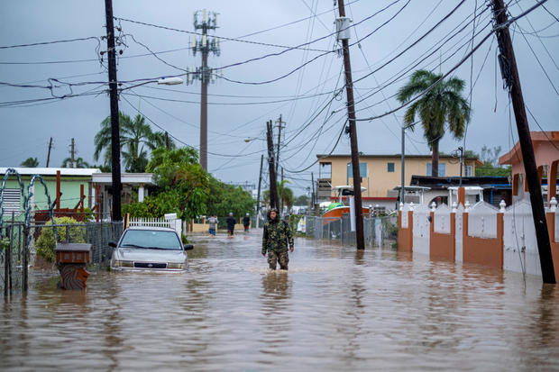 A member of the Puerto Rico National Guard wades through water searching for people in need of rescue from flooded streets in the aftermath of Hurricane Fiona in Salinas, Puerto Rico, on Sept. 19, 2022. 