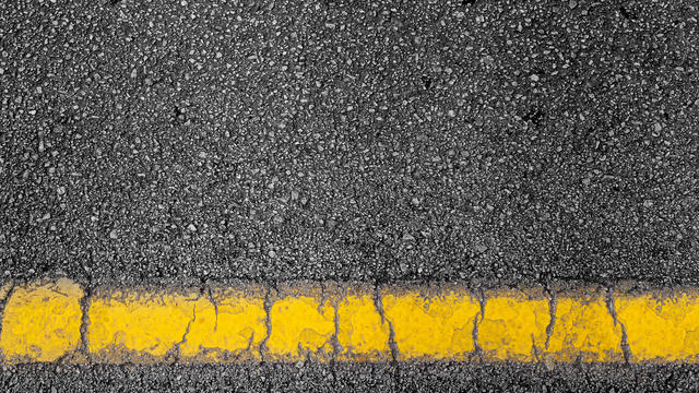 top view of a black dark road street tarmac surface background texture with copy space yellow line marking 
