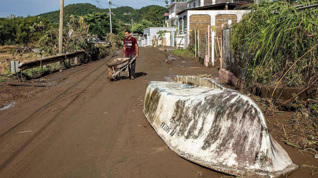 Samuel Santiago removes mud from the front of his house in the San Jose de Toa Baja neighborhood on Tuesday, Sept. 20, 2022. 