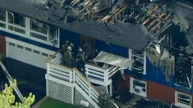 Authorities attempt to enter a house in Oak Forest, Illinois, after the house caught fire during an incident Sept. 23, 2022. 