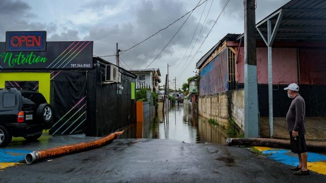 A man looks at a flooded street in the Juana Matos neighborhood of Catano, Puerto Rico, on September 19, 2022, after the passage of Hurricane Fiona. 