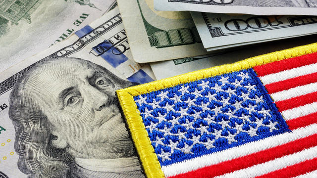 USA flag and money. Cash for VA loan from U.S. Department of Veterans Affairs. 