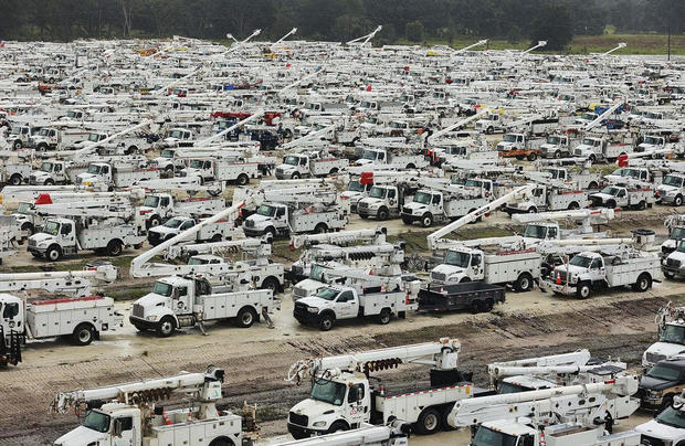 Utility trucks are staged in a rural lot in preparation for Hurricane Ian 