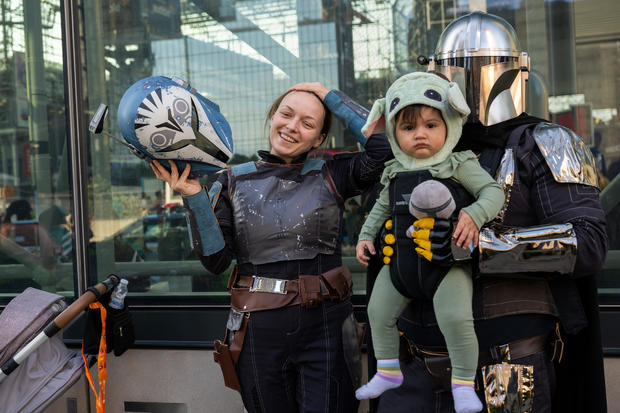 A family dressed as Star Wars' Bo Katan, Mandalorian and Baby Yoda (Grogu) pose outside Comic Con on October 07, 2022 in New York City. 