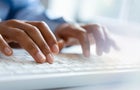 Hands of young woman typing on computer keyboard 