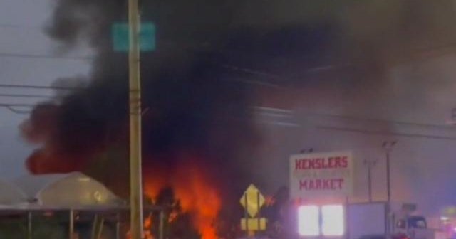 2 dead after plane crashes into car dealership