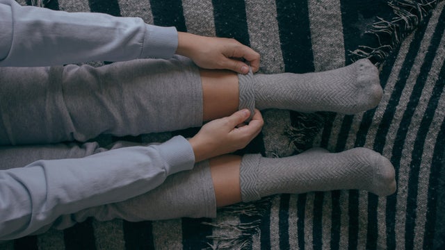 Girl puts on some socks on a cold day 