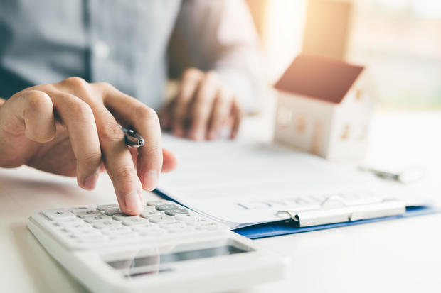 Home agents are using a calculator to calculate the loan period every month for the customer. 