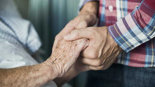 Close up of son holding his mothers hands 