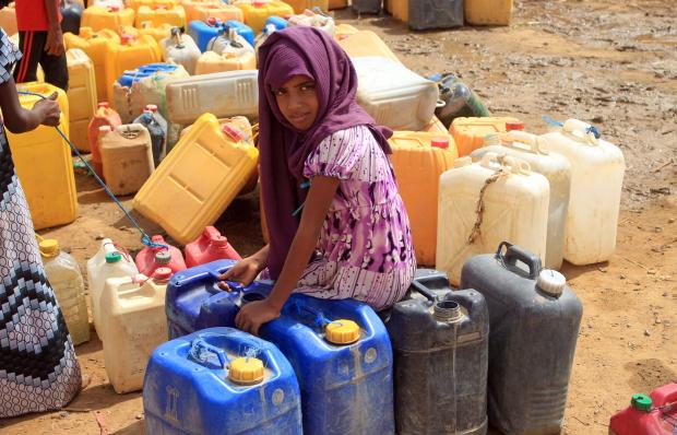 A Yemeni girl waits as others fill their jerrycans with water at a makeshift camp for the internally displaced, in the northern Hajjah province on June 4, 2022, amid a severe heat wave and acute water shortage. 
