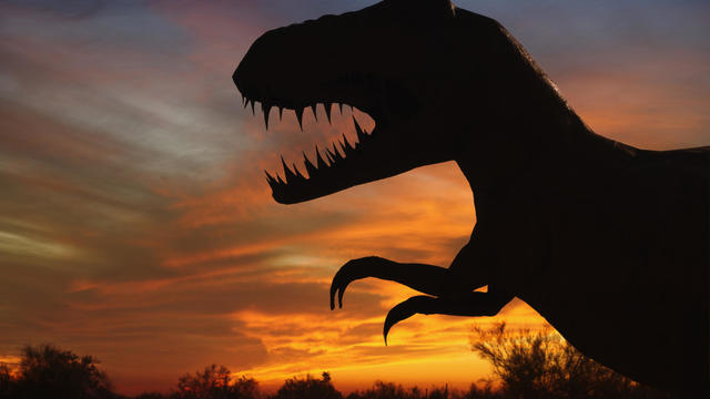 Silhouette of dinosaur sculpture at sunset, Moab, Utah, USA 