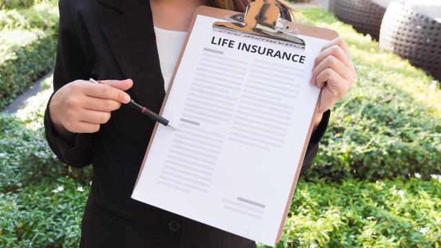 Midsection Of Female Agent With Life Insurance Documents In Yard 