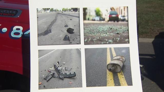 A poster board displays photos of debris left in roads after car crashes. 