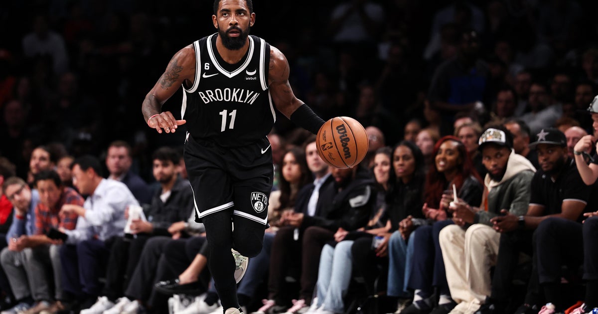 Fans wearing 'Fight Antisemitism' shirts sit courtside at Nets