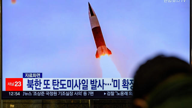 A TV screen shows a file image of North Korea's missile 