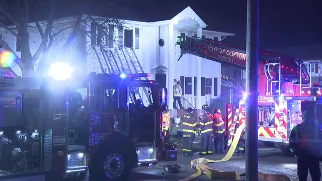 Firefighters and fire trucks outside a home in Clifton. 