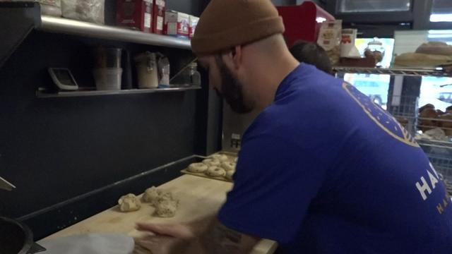 Matt Harvey rolls bagels in the kitchen of his bagel shop. 