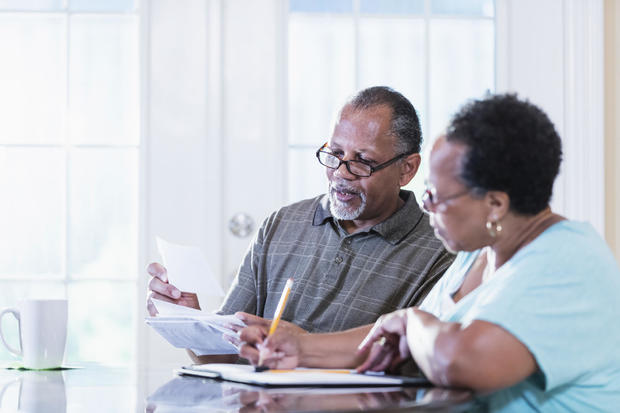 Senior couple at home paying bills 