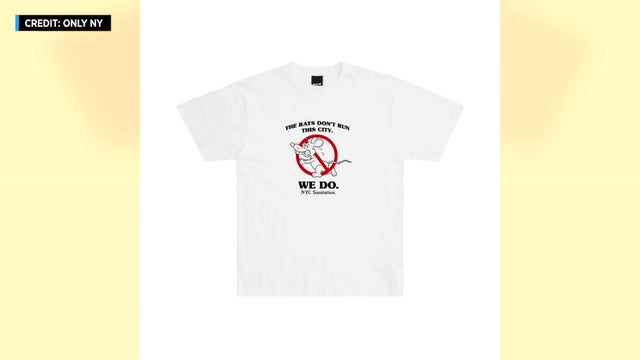 A t-shirt with a cartoon of a frightened rat with a red circle and cross over it. It reads "The rats don't run this city. We do. NYC Sanitation." 