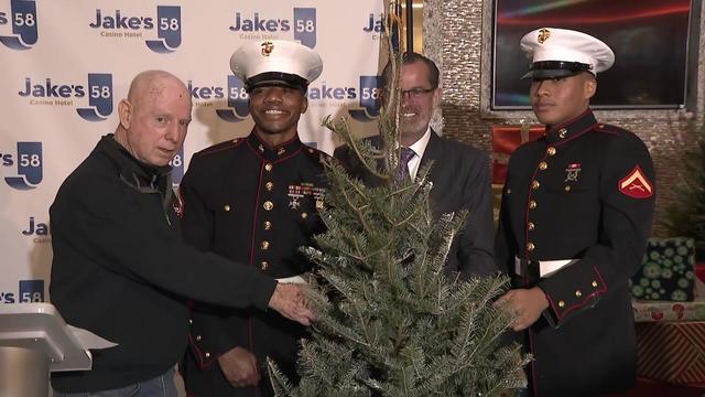 Officials with the Suffolk OTB pose with Marines and a Christmas tree. 