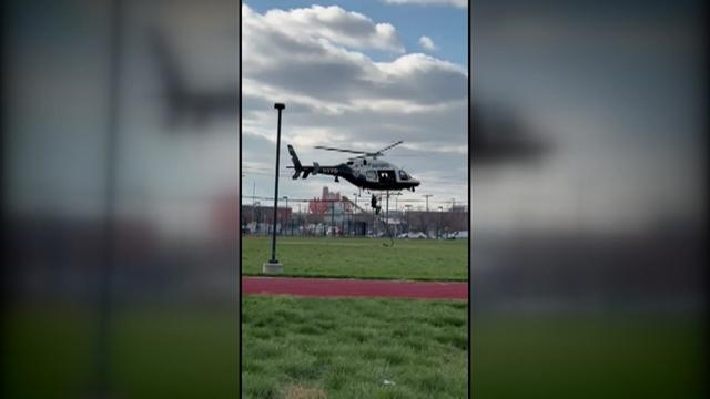 An officer falls from an NYPD helicopter hovering over a field. 