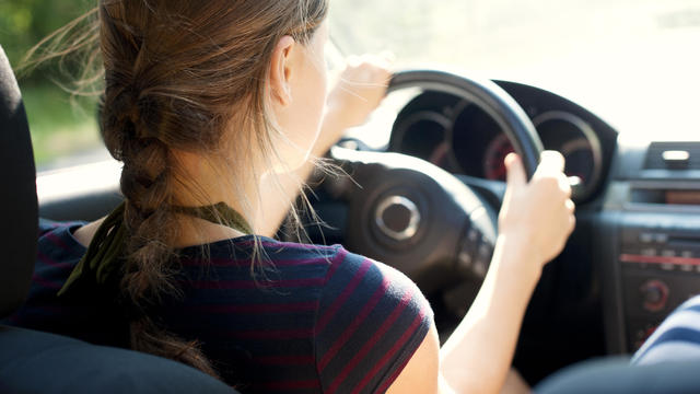 Rear view of teenage girl driving car 
