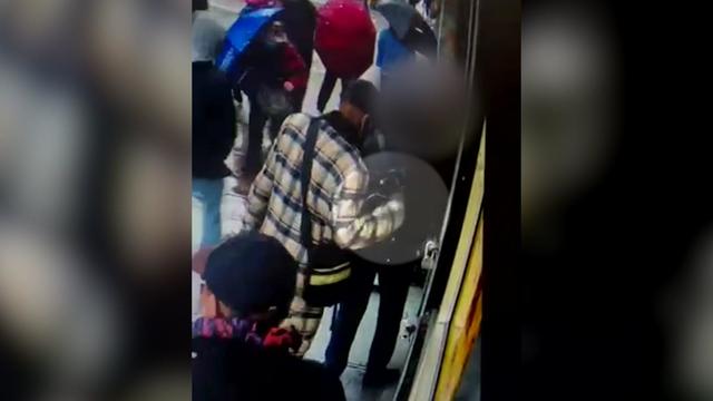 A video shows an alleged pickpocket reaching into someone's backpack. 