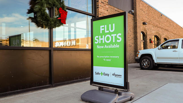 A sign outside of a Wegmans supermarket advertises flu shots 
