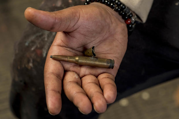 Mykael Ash holds bullet shells he found on the street 