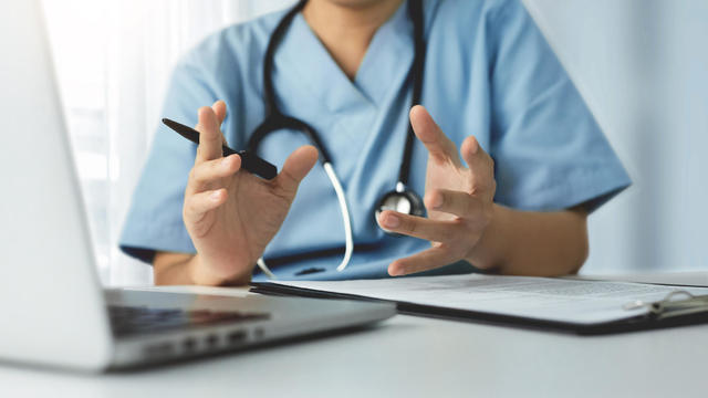 Surgeon Female Doctor making video call meeting with physician team on laptop 