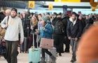 A crowd of people in front of airline counters 