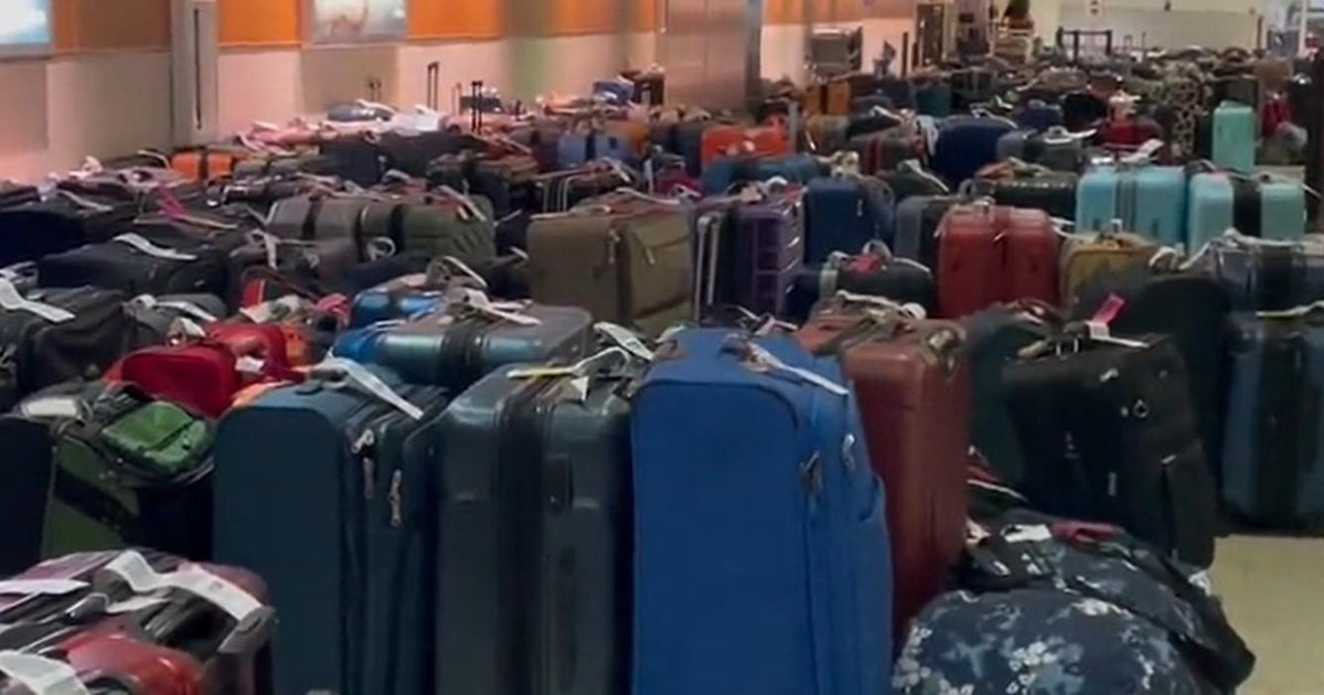 Travelers wait to be reconnected with luggage as hundreds