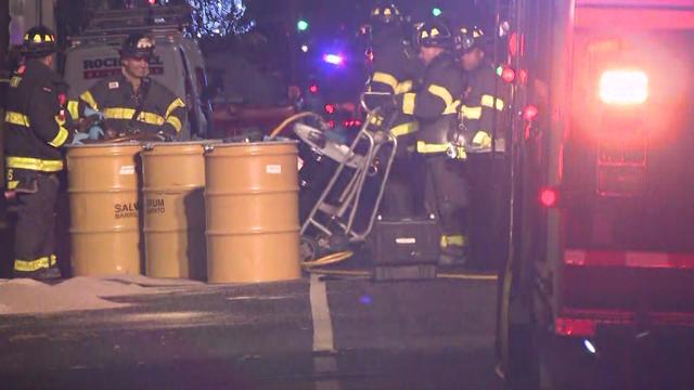 Firefighters push fuel containers on a New York City street. 