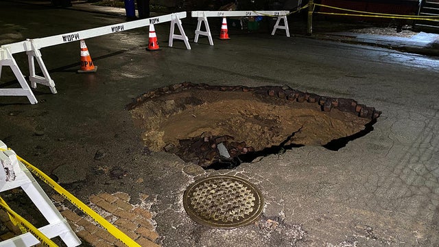 Vehicle falls into sinkhole along residential street in