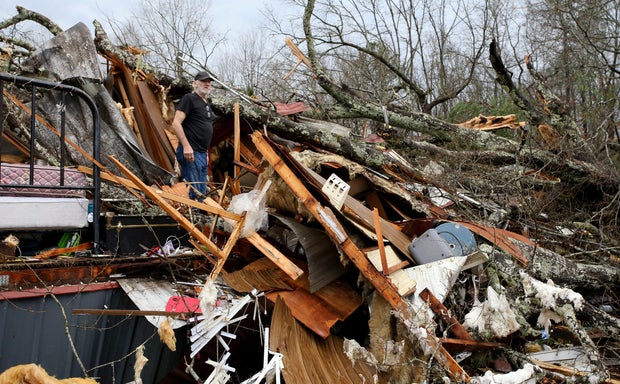 Larry Fondren sorts through the rubble of his mobile home destroyed by a tornado in Alabama 