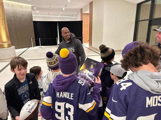 Woman dressed in Adrian Peterson jersey, holding switch at Vikings tailgate  (Photo)