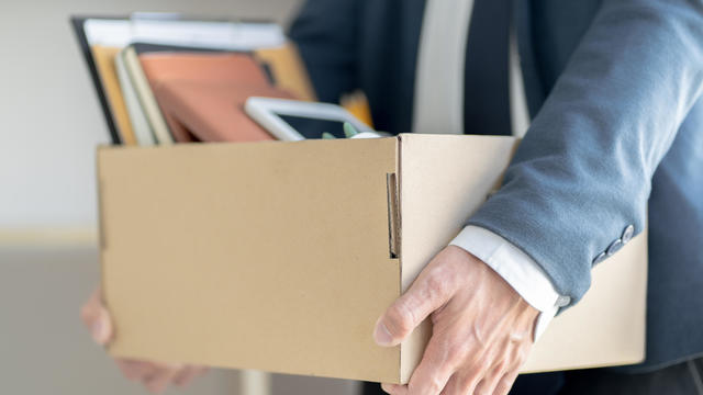 Midsection Of Businessman Carrying Cardboard Box 