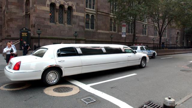 A limousine drives down a New York City street. 